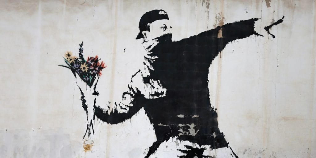 Grafite de Banksy demonstrando técnicas realistas em muro